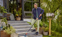 uomo lava i gradini di casa con una spazzola con manico Gardena
