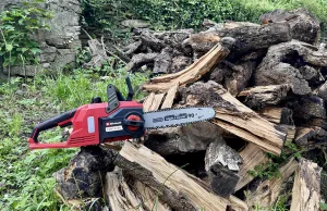 motosega Einhell su catasta di legna